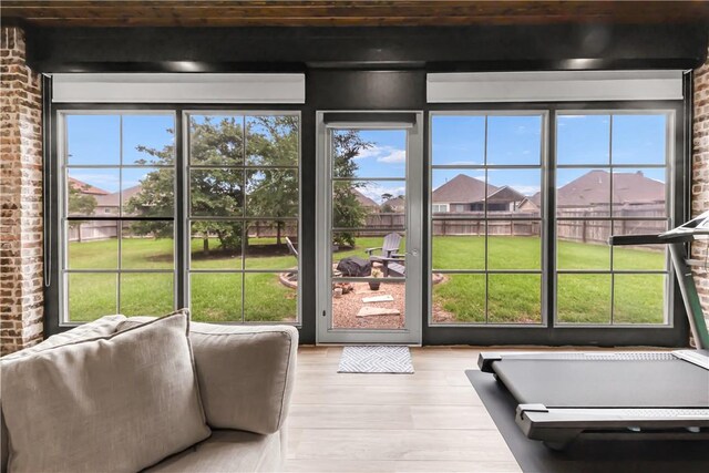 4813 Coopers Hawk Dr, College Station, TX 77845 - doorway featuring plenty of natural light, brick wall, light wood-type flooring, and a residential view