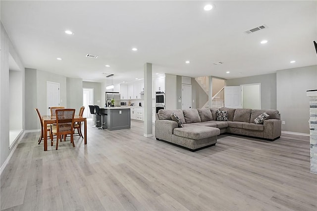 living room with sink and light hardwood / wood-style floors