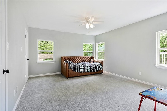 carpeted bedroom featuring multiple windows and ceiling fan