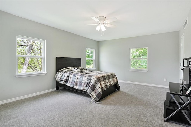 carpeted bedroom featuring multiple windows and ceiling fan