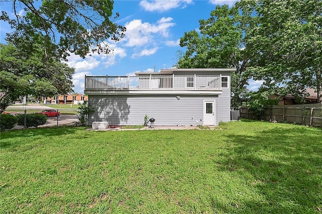 rear view of house featuring a lawn, a balcony, and central AC