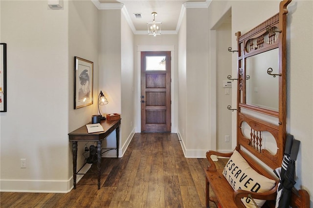 entrance foyer featuring dark wood-type flooring, ornamental molding, and a chandelier