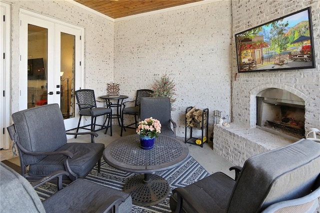 view of patio featuring a brick fireplace and french doors