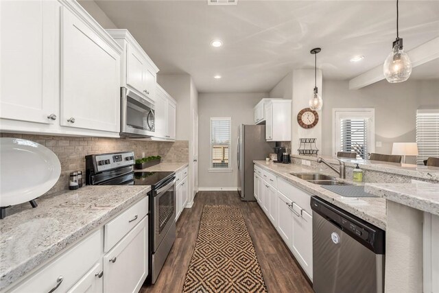 kitchen featuring decorative light fixtures, tasteful backsplash, white cabinetry, stainless steel appliances, and light stone countertops