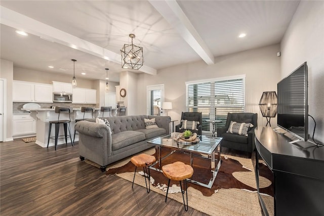 living room with beamed ceiling, an inviting chandelier, and dark wood-type flooring