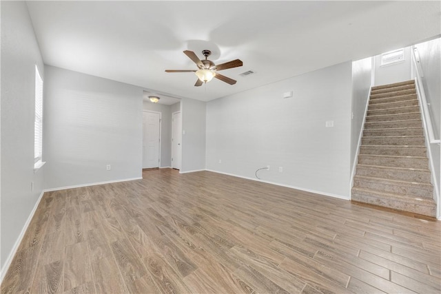 empty room with ceiling fan and light hardwood / wood-style floors