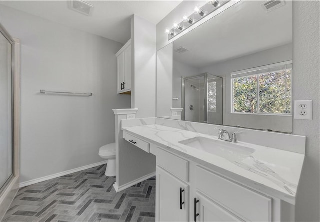 bathroom with vanity, a shower with shower door, and toilet