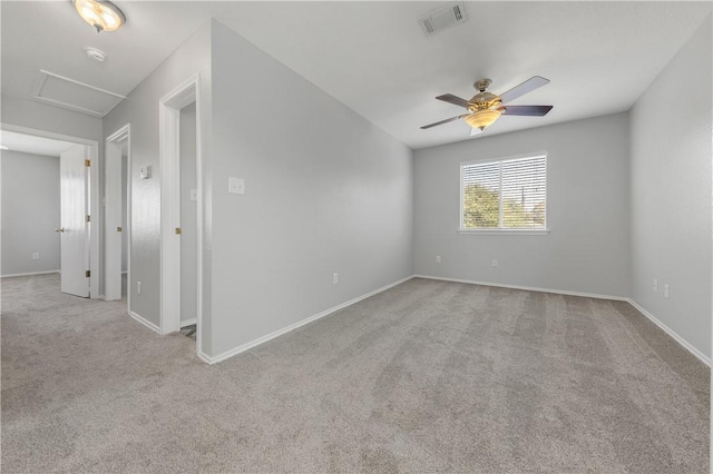 spare room with ceiling fan and light colored carpet