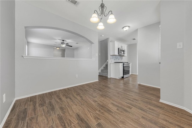 unfurnished living room featuring dark wood-type flooring and ceiling fan with notable chandelier