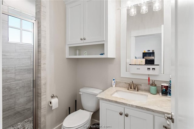 bathroom featuring vanity, a shower with shower door, and toilet