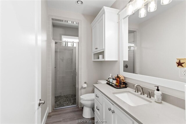 bathroom with hardwood / wood-style flooring, toilet, and walk in shower