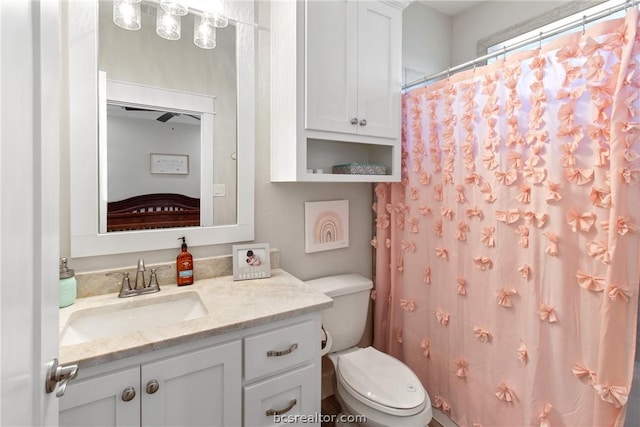 bathroom featuring vanity, toilet, and walk in shower