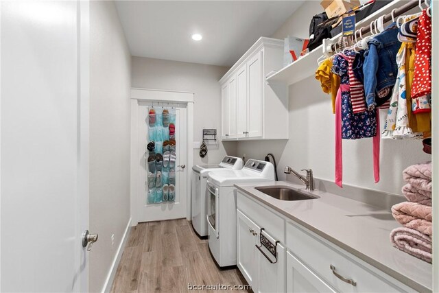 washroom featuring cabinets, sink, light hardwood / wood-style floors, and independent washer and dryer