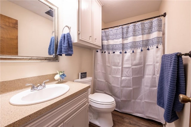 bathroom with a shower with curtain, vanity, wood-type flooring, and toilet