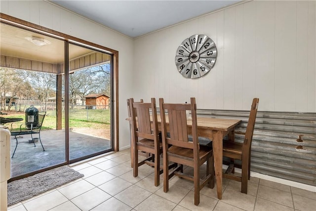 dining space with light tile patterned floors and wooden walls