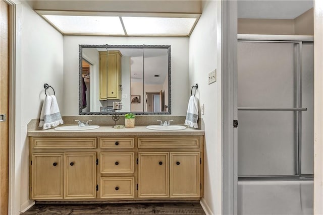 bathroom featuring a shower with door and vanity