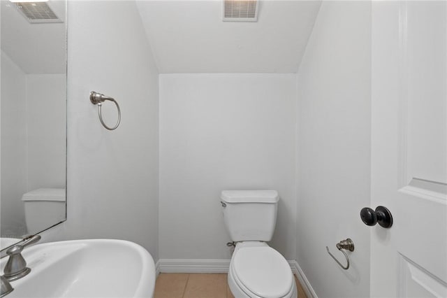 4412 Hearst Ct, College Station, TX 77845 - half bathroom featuring a sink, toilet, baseboards, tile patterned floors, and vaulted ceiling