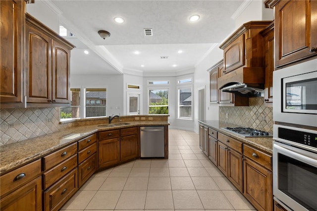 4412 Hearst Ct, College Station, TX 77845 - kitchen featuring appliances with stainless steel finishes, a sink, stone counters, backsplash, and light tile patterned floors