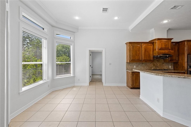 4412 Hearst Ct, College Station, TX 77845 - kitchen featuring light stone counters, decorative backsplash, under cabinet range hood, light tile patterned floors, and crown molding