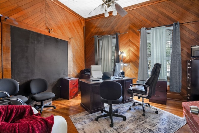 office featuring ceiling fan, light wood-type flooring, and wood walls