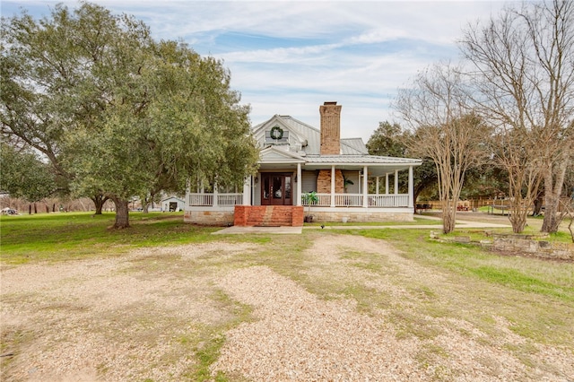 farmhouse with a porch and a front lawn