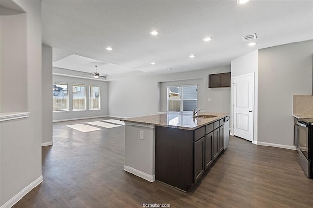 5769 Paseo Pl, Bryan, TX 77807 - kitchen with light stone counters, dark wood finished floors, dark brown cabinetry, recessed lighting, and a ceiling fan