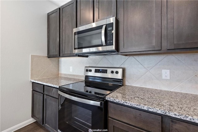 5769 Paseo Pl, Bryan, TX 77807 - kitchen featuring range with electric stovetop, stainless steel microwave, dark brown cabinetry, and tasteful backsplash
