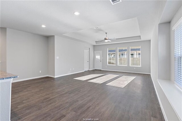 5769 Paseo Pl, Bryan, TX 77807 - unfurnished living room with a tray ceiling, ceiling fan, dark wood-style flooring, and recessed lighting