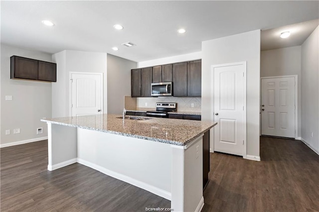 5769 Paseo Pl, Bryan, TX 77807 - kitchen with appliances with stainless steel finishes, dark brown cabinetry, dark wood-type flooring, and recessed lighting