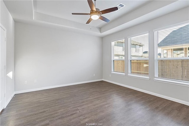 5769 Paseo Pl, Bryan, TX 77807 - unfurnished room featuring a tray ceiling, dark wood-style floors, and ceiling fan