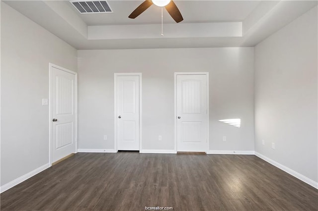 5769 Paseo Pl, Bryan, TX 77807 - unfurnished bedroom featuring a raised ceiling, dark wood-type flooring, and a ceiling fan