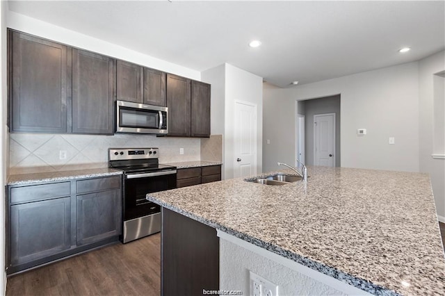 5769 Paseo Pl, Bryan, TX 77807 - kitchen featuring appliances with stainless steel finishes, dark wood finished floors, tasteful backsplash, dark brown cabinets, and recessed lighting