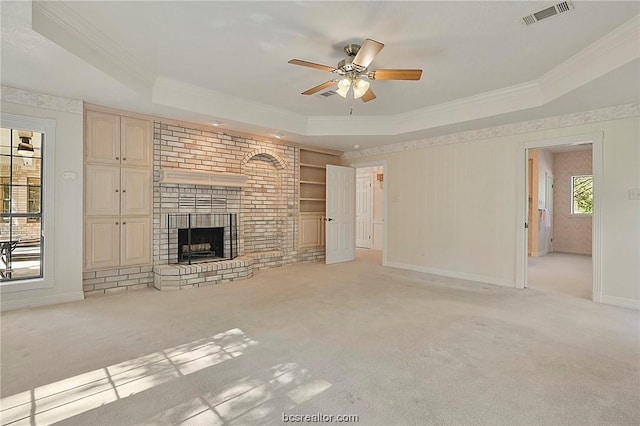 unfurnished living room with a fireplace, a tray ceiling, ceiling fan, and light colored carpet