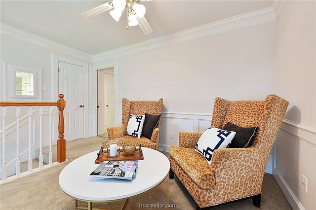 sitting room featuring ceiling fan, carpet floors, and ornamental molding