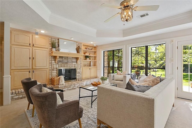 living room featuring a healthy amount of sunlight, a raised ceiling, and light carpet