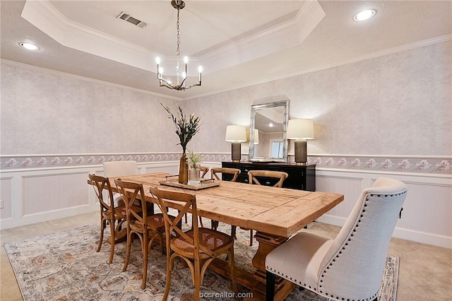 dining room with a raised ceiling and ornamental molding