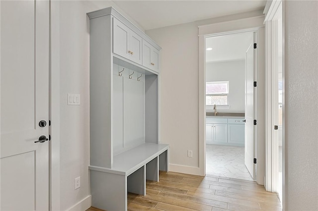 7888 Mathis Creek Dr, Bryan, TX 77808 - mudroom featuring light wood-type flooring, a sink, and baseboards
