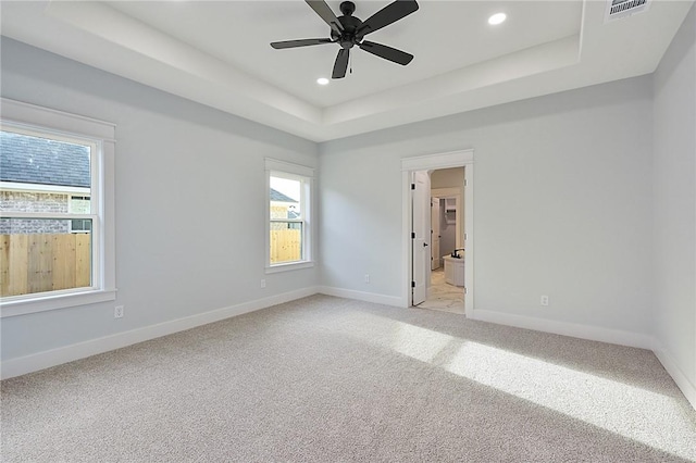 7888 Mathis Creek Dr, Bryan, TX 77808 - empty room featuring a tray ceiling, healthy amount of natural light, light carpet, recessed lighting, and baseboards