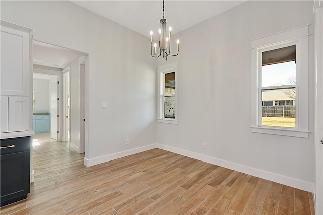 7888 Mathis Creek Dr, Bryan, TX 77808 - unfurnished room featuring a chandelier, light wood-style floors, and baseboards