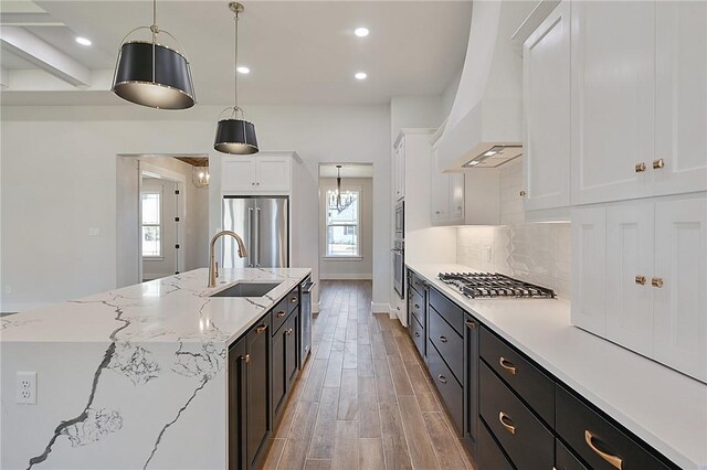 7888 Mathis Creek Dr, Bryan, TX 77808 - kitchen with appliances with stainless steel finishes, premium range hood, a sink, healthy amount of natural light, and recessed lighting