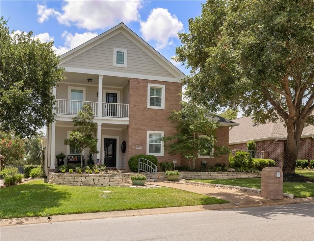 greek revival house with a balcony and a front lawn