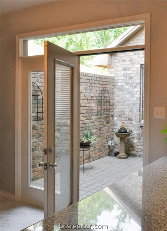 doorway featuring french doors and brick wall