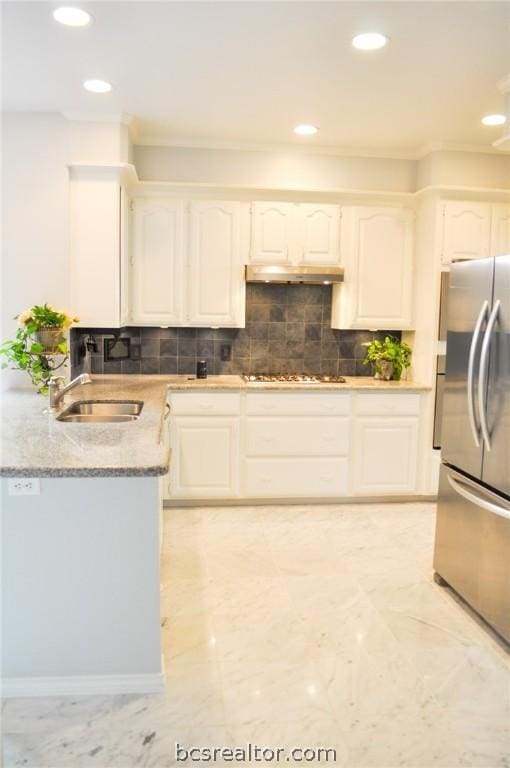 kitchen featuring white cabinetry, stainless steel refrigerator, tasteful backsplash, and sink