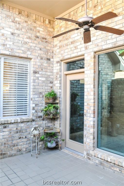 view of exterior entry with ceiling fan and a patio area