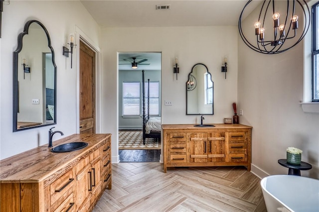 bathroom with ceiling fan with notable chandelier, parquet flooring, and vanity