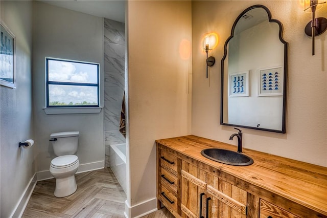 full bathroom with toilet, tiled shower / bath, vanity, and parquet flooring