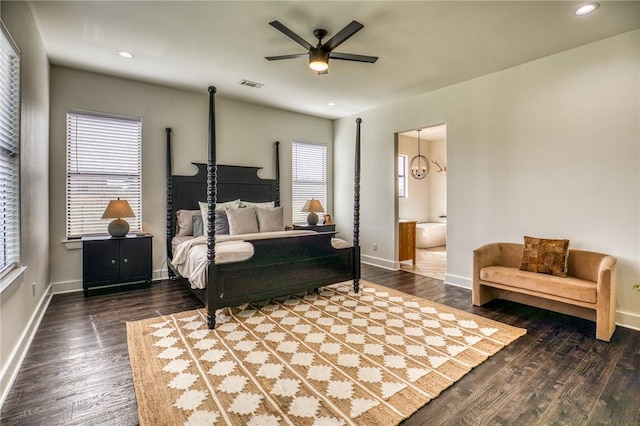 bedroom with ceiling fan with notable chandelier, multiple windows, wood-type flooring, and ensuite bathroom