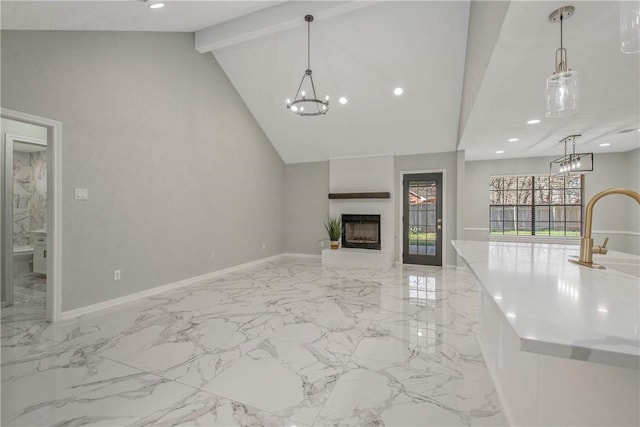 unfurnished living room with baseboards, beamed ceiling, an inviting chandelier, a fireplace, and recessed lighting