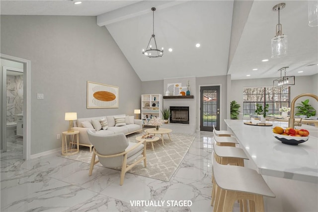 living area with marble finish floor, a fireplace, beamed ceiling, and an inviting chandelier