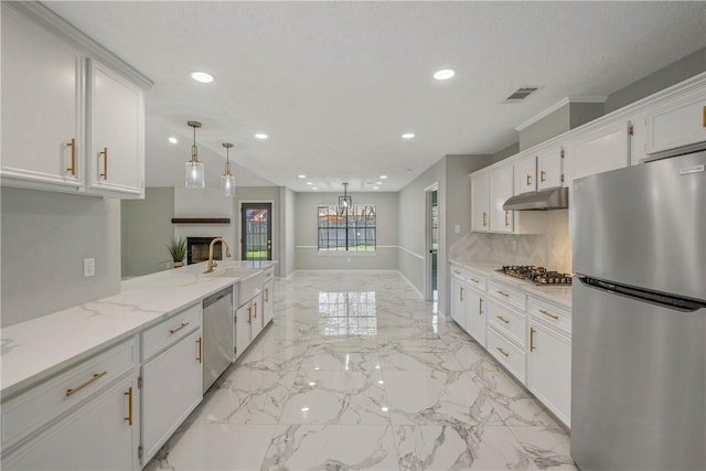 kitchen featuring appliances with stainless steel finishes, light stone countertops, under cabinet range hood, white cabinetry, and a sink